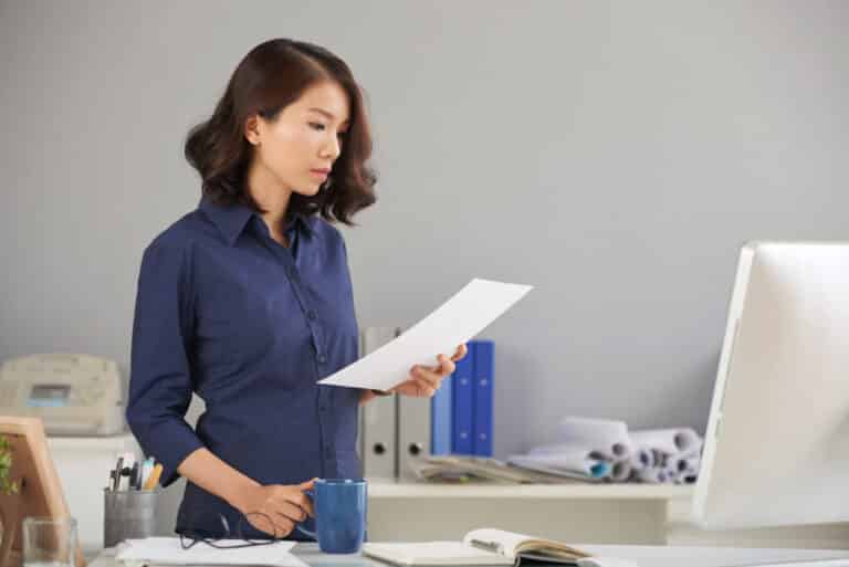 Frau im Büro liest aufmerksam ein Dokument