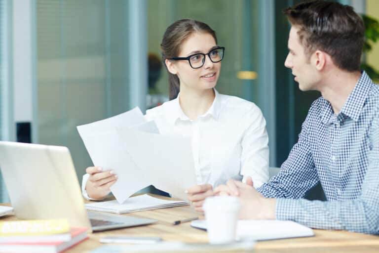 Zwei Kollegen besprechen im Büro gemeinsam Unterlagen